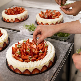Jeune réalisant un fraisier