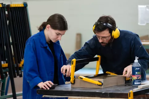 Une jeune et son professeur en train de travailler sur un projet 