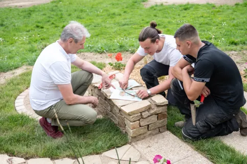 Deux jeunes en formation Aménagements Paysagers réfléchissent avec leur formateur sur leur scène paysagère
