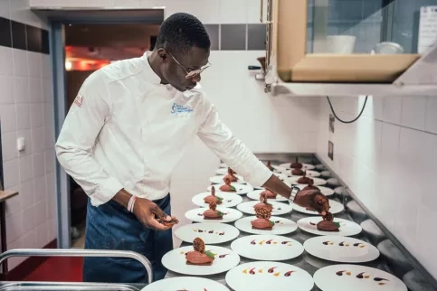Jeune homme dressant des assiettes de desserts