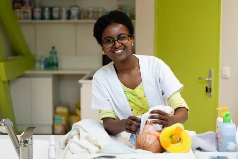 Jeune en formation service à la personne s'occupant d'un faux bébé