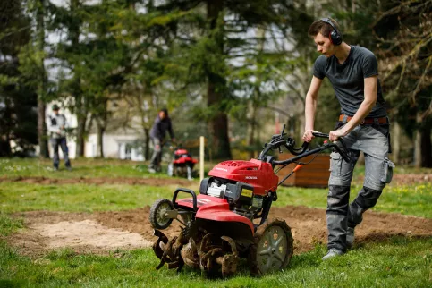 Jeune en train de passer la tondeuse à gazon au Campus Saint-Antoine