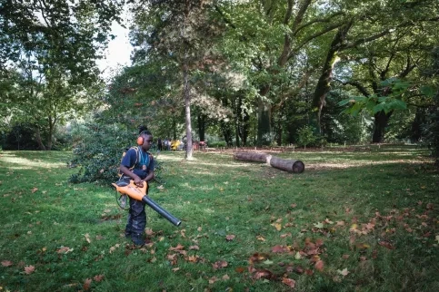 Jeune en formation qui souffle les feuilles à Marcoussis