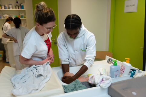 Deux jeunes en formation service à la personne donne un bain à un faux bébé