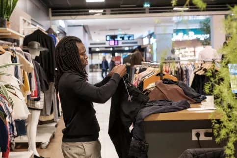 Zackaria dans la boutique éphèmère SKOLA s'occupe des vêtements