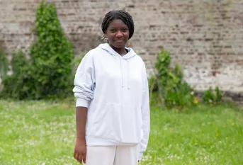 Une jeune femme face à l'objectif dans un jardin