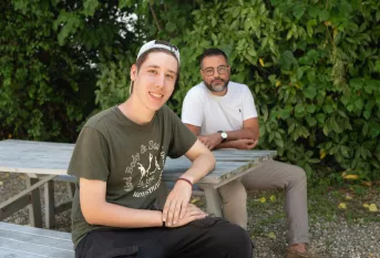 un jeune et son éducateur assis sur un banc