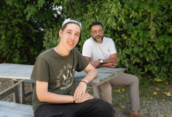 un jeune et son éducateur assis sur un banc