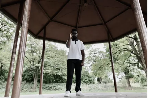 Jeune d'Impact Jeune participant au programme Objectif Clique, posant sous une tonnelle 