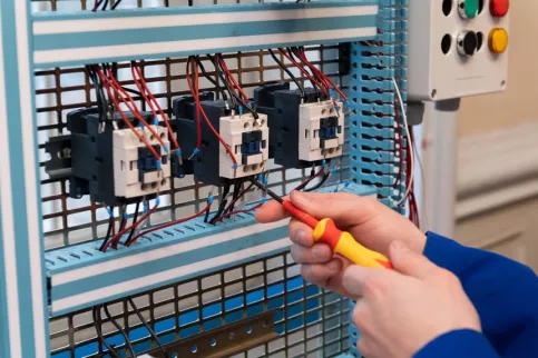 Un jeune en BAC PRO MELEC en train de travailler sur un cheminement de câbles