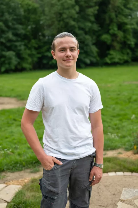 Jeune homme face à l'objectif dans un parc