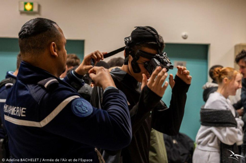 Jeune avec un casque de réalité virtuelle que lui met un gendarme