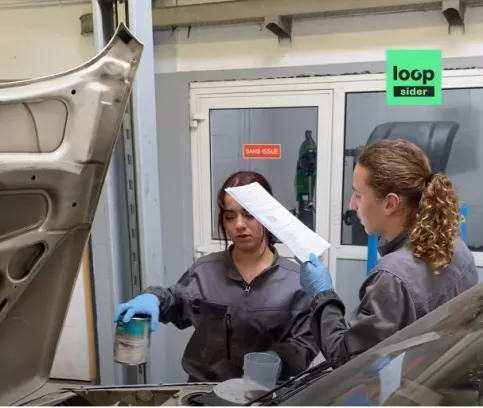 Deux jeunes en formation mécanique automobile travaillent sur une voiture