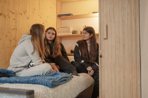 Jeunes filles à l'internat sur un lit