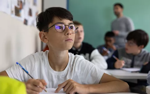 Rentrée des 6èmes au campus éducatif et écologique Saint-Philippe, Giulian  note le nom des enseignants sur son carnet scolaire