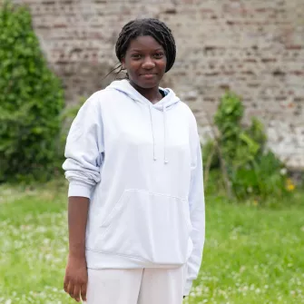 Une jeune femme face à l'objectif dans un jardin