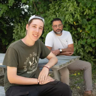 un jeune et son éducateur assis sur un banc