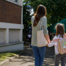 Une maman et sa fille dans la cour de récréation, de dos