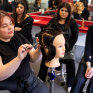 Formatrice de CAP coiffure expliquant à des jeunes une technique de coiffure