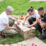 Deux jeunes en formation Aménagements Paysagers réfléchissent avec leur formateur sur leur scène paysagère