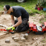 Jeune à genoux travaillant sur une scène paysagère