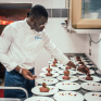 Jeune homme dressant des assiettes de desserts