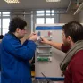 Un jeune et son formateur en électricité travaillent sur un plateau technique