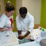 Deux jeunes en formation service à la personne donne un bain à un faux bébé